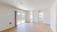 Located at 9008 NE Hassalo St in Portland, Oregon, this 2-bedroom, 1-bathroom single-floor home offers a clean, well-maintained layout with a bright and functional design throughout. Light wood-style flooring runs continuously across the entire space, creating a cohesive and open feel.

The combined living and dining area serves as the heart of the home, featuring a textured ceiling, crisp white walls, and a sliding glass door that floods the room with natural light while providing direct access to an outdoor patio area. The kitchen is efficiently laid out with white shaker-style cabinetry, brushed hardware, light quartz countertops, a white electric range, and a window above the dining area paired with a ceiling fan for added comfort.

The two bedrooms are well-proportioned, with the primary bedroom offering a sliding closet and natural light. Both rooms feature the same light wood flooring and textured ceilings. The bathroom is cleanly finished with a single vanity featuring a quartz countertop, white cabinetry, a soaking tub, and a window that brings in natural light. A hallway connects the private areas of the home, and an entrance area provides a clear transition into the living space.