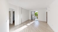 This contemporary apartment in Boca Raton, FL, offers 1050 square feet of thoughtfully designed living space. The single-story layout comprises three bedrooms, including a spacious 170 sq ft primary bedroom, and two well-appointed bathrooms. The interior showcases a bright, open-concept design with a cohesive aesthetic throughout.

Light wood-look flooring unifies the space, complementing the crisp white walls and ceilings. The kitchen is a highlight, featuring sleek white cabinetry, stainless steel appliances, and a central island, perfect for casual dining or food preparation. Track lighting and pendant fixtures provide both ambient and task lighting.

The bathrooms boast modern fixtures, with one featuring a glass-enclosed shower and another offering a shower/tub combination. Large windows in the bedrooms and living areas flood the space with natural light, while horizontal blinds offer privacy control. A sliding glass door leads to a balcony, providing a connection to the outdoors and views of tropical landscaping.

Storage is ample, with closets in the bedrooms and additional built-in shelving. The apartment's neutral color palette and clean lines create a canvas for personal style, making it suitable for a variety of tastes and lifestyles. This well-designed space combines functionality with contemporary flair, offering a comfortable and stylish urban living experience in Boca Raton.