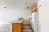 Located at 2224 Golfside Rd in Ypsilanti, Michigan, this one-bedroom, one-bathroom unit offers a practical and well-organized single-floor layout. The combined kitchen and living area forms the heart of the space, with light-toned luxury vinyl plank flooring running throughout. The kitchen is equipped with warm oak cabinetry, a peninsula with a double-basin sink, laminate countertops, and white appliances including a coil-top range, dishwasher, and refrigerator — providing ample functionality for everyday cooking. The adjoining living area is bright and open, featuring a large window dressed with vertical blinds that allows natural light to fill the room. The bedroom is a comfortable size, finished with plush carpeting and its own closet with built-in wire shelving for organized storage, plus an additional walk-in closet nearby offering generous wardrobe space. The full bathroom includes a tub/shower combination, a single vanity with oak cabinetry and a large mirror, and wood-look flooring for easy maintenance. A dedicated laundry area houses a full-sized washer and dryer, adding notable convenience. Throughout the unit, neutral white walls and clean finishes contribute to a bright, move-in ready atmosphere.
