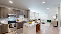 Located at 22103 Gosling Road in Spring, TX, this one-bedroom, one-bathroom residence offers a thoughtfully designed open-concept floor plan spread across a single level. The kitchen serves as the heart of the home, showcasing rich dark cabinetry, white subway tile backsplash, granite countertops, and a full suite of stainless steel appliances including a French door refrigerator, gas range, microwave, and dishwasher. A central island with a granite surface and bar seating provides additional workspace and casual dining. Light wood-look flooring runs throughout, lending warmth and continuity to the entire space. The living room is filled with natural light from multiple large windows dressed with clean white blinds, and is equipped with a modern ceiling fan. The bedroom is a quiet, comfortable retreat featuring its own ceiling fan, a window for natural light, and a dedicated closet. The bathroom is well-appointed with a granite-topped vanity, dark wood cabinetry, a soaking tub with white subway tile surround, and wood-look flooring. Recessed lighting throughout the home ensures consistent, modern illumination, while neutral wall tones create a calm and versatile ambiance suited to a variety of interior styles.
