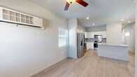 Located in Pueblo, CO, this single-story, one-bedroom, one-bathroom home offers a well-designed layout that maximizes every square foot of its compact footprint. Light-toned luxury vinyl plank flooring runs throughout the main living areas, complementing the neutral color palette and creating a clean, cohesive aesthetic. Ceiling fans are present in multiple rooms, and a wall-mounted HVAC unit provides efficient climate control in the main living space.

The kitchen is a standout feature, outfitted with crisp white cabinetry, grey subway tile backsplash, granite countertops, and a full suite of stainless steel appliances including a refrigerator with ice maker, electric range, over-the-range microwave, and dishwasher. A window above the sink brings in natural light.

The bedroom is a comfortable retreat, carpeted for warmth, with two windows that offer views of the surrounding landscape and a wall unit for individual climate control. Bold navy-blue arched interior doors add a distinctive design touch throughout, including access to two closets conveniently located off the bedroom.

A versatile den provides additional flexible living space, also finished with luxury vinyl plank flooring and a ceiling fan. The bathroom features a full tub/shower combo with built-in shelving. Completing the home is a dedicated laundry area, adding everyday convenience to this thoughtfully appointed residence.