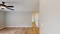 This 2-bedroom, 2-bathroom single-story home in Fayetteville, Arkansas offers a practical and well-organized layout. Light-toned luxury vinyl plank flooring runs throughout, complementing the neutral gray and beige wall tones that create a clean, cohesive aesthetic. Textured ceilings and ceiling fans are present in the main living areas and both bedrooms, adding comfort and functionality.

The combined kitchen and living area forms the heart of the home. The kitchen features warm wood-toned cabinetry, white countertops, a stainless steel sink, dishwasher, and refrigerator, along with a separate pantry for additional storage. The living area opens through French doors to the outdoors, allowing natural light to fill the space.

Both bedrooms are well-proportioned, each equipped with a ceiling fan and closet storage. The primary bedroom connects directly to its own bathroom and includes a dedicated closet. The second bedroom also features a closet and is conveniently positioned near the second bathroom.

The two bathrooms are finished with wood-toned vanities, white countertops, brushed nickel fixtures, and tub-shower combinations. With five closets total distributed throughout the home, storage is a notable strength. A hallway connects the private areas of the home, creating a logical and functional flow.