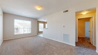 This well-appointed 1-bedroom, 1-bathroom residence offers a thoughtfully designed single-floor layout with generous living space throughout. The open-concept living and dining area features plush wall-to-wall carpeting, neutral-toned walls, and large windows that invite abundant natural light, creating a bright and welcoming atmosphere. A pass-through opening connects the living area to the kitchen, enhancing the sense of openness and flow between spaces.

The kitchen is a functional highlight, featuring white cabinetry, granite-style countertops, wood-look flooring, and a full suite of black appliances including a refrigerator, range, dishwasher, and built-in range hood. Warm accent wall colors and ample cabinet storage make this kitchen both practical and visually appealing.

The bedroom is generously sized, with soft carpeting, a ceiling fan, large windows offering neighborhood views, and direct access to a spacious walk-in closet equipped with wire shelving for organized storage. The bathroom includes a full tiled tub and shower combo with clean, classic finishes and wood-look flooring.

A dedicated in-unit laundry area accommodates a full-size washer and dryer side by side, complete with overhead wire shelving for added convenience. This residence combines comfort, functionality, and a clean, move-in-ready aesthetic.