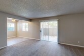 Located at 4620 W Douglas Ave in Visalia, CA, this single-floor, 2-bedroom, 2-bathroom home offers a well-organized layout with functional living spaces throughout. The living room is generously sized, featuring plush carpeting, a ceiling fan, a side window for natural light, and a full-width sliding glass door fitted with vertical blinds that opens to an outdoor view. The textured ceiling adds a classic touch consistent throughout the home. The combined dining and kitchen area transitions to light-toned luxury vinyl plank flooring and features gray shaker-style cabinetry, white countertops, recessed lighting, a ceiling fan, and white appliances including a refrigerator and dishwasher. A window above the sink brings in additional natural light. Both bedrooms are carpeted and bathed in natural light from windows with blinds. Each bedroom includes dedicated closet space, with the primary bedroom offering two side-by-side closets. The two bathrooms are finished with light LVP flooring, dark gray vanity cabinetry, white countertops, and a tub-shower combination. A hallway connects the bedrooms, and four closets throughout the home provide ample storage. Neutral wall tones and clean finishes give the entire space a move-in ready, cohesive aesthetic.