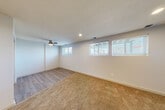 Located at 6964 Hansen Plaza in Omaha, Nebraska, this single-floor home offers a practical and well-organized layout across three bedrooms, three bathrooms, and one kitchen. The bedrooms feature warm, neutral-toned carpet flooring and are finished with clean white walls and textured ceilings. Each bedroom is equipped with a ceiling fan with integrated lighting and includes windows with blinds that allow natural light to filter in. The spacious primary bedroom provides a generous amount of room for comfortable furnishing. The galley-style kitchen is efficiently designed with white cabinetry, granite-look countertops, a stainless steel sink, and wood-look vinyl plank flooring. White appliances, including a refrigerator, range, and over-the-range microwave, are included. The three bathrooms maintain a consistent, clean aesthetic, each featuring tub-shower combinations with white tile surrounds, wood-look vinyl plank flooring, and white vanities. Hallways connect the rooms with continuity, and a dedicated closet adds useful storage. The overall interior palette of whites and neutrals creates a bright, move-in-ready atmosphere throughout the home.