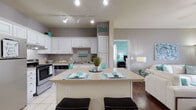 Located at 7875 Shadow Creek Dr in Hamilton, Ohio, this single-floor residence offers a well-designed layout that balances comfort and functionality. The open-concept kitchen is a standout feature, showcasing crisp white cabinetry, stainless steel appliances including a refrigerator, electric range, and dishwasher, complemented by light countertops and tile flooring. Track lighting illuminates the space, while a peninsula with bar seating provides a convenient casual dining option. The kitchen flows seamlessly into the living area, which features rich hardwood-style flooring, neutral walls, and a sliding glass door that draws in natural light and provides outdoor access. The bedrooms offer plush carpeting, large windows with ample natural light, and restful, well-proportioned spaces. The primary bedroom includes generous storage. Both bathrooms are finished with tile flooring and include a tub-shower combination. A dedicated in-unit laundry area adds everyday convenience. The consistent use of neutral tones throughout the home creates a cohesive, welcoming atmosphere, making this a practical and comfortable residence in the Shadow Creek community.