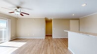 Located at 2315 Zlaten Dr in Longmont, CO, this single-floor, one-bedroom, one-bathroom home offers a well-organized layout with consistent design throughout. The open-concept living room and kitchen area is anchored by warm wood-look flooring, neutral beige walls, and crown molding, creating a clean and inviting atmosphere. A ceiling fan with a light fixture adds both comfort and functionality, while recessed lighting and natural light streaming through windows brighten the space. The kitchen is well-appointed with rich dark cabinetry, light granite-style countertops, stainless steel appliances including a refrigerator, range, microwave, and dishwasher, and a convenient breakfast bar that connects to the living area. The bedroom is a comfortable, sunlit room featuring a ceiling fan, crown molding, and a sliding glass door that opens to an outdoor area with open views. A dedicated closet provides ample storage. The bathroom includes a full tub and shower combination with clean white surrounds and hardwood-style flooring. Throughout the home, the consistent use of neutral tones, wood-look flooring, and white trim creates a cohesive, move-in-ready aesthetic ideal for easy, comfortable living.