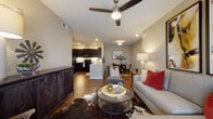 Located at 1151 Mallard Way in Kerrville, Texas, this single-floor residence offers a thoughtfully designed open-concept layout that seamlessly connects the living, dining, and kitchen areas. Rich hardwood-style flooring runs throughout the main living spaces, anchoring the warm, contemporary aesthetic.

The kitchen is a standout feature, outfitted with dark espresso cabinetry reaching to the ceiling, granite countertops, black appliances including a refrigerator, range, and built-in microwave, and under-cabinet lighting that adds a polished touch. A peninsula with bar seating provides a convenient casual dining option. Adjacent to the kitchen, a dedicated dining area offers an intimate space for sit-down meals.

The living room is spacious and inviting, centered around a ceiling fan with a light fixture and recessed lighting. It flows naturally into the dining space, making the layout ideal for everyday living and entertaining.

The bedrooms are carpeted for comfort and feature large windows that invite natural light and offer outdoor views. The primary bathroom is well-appointed with a granite-topped vanity with dark cabinetry, a tub-shower combination, and access to a walk-in closet. Neutral tones throughout the residence create a calm, cohesive atmosphere with a subtle Texas-inspired character.