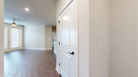 This thoughtfully laid-out single-story residence offers three bedrooms and three full bathrooms across a comfortable and functional floor plan. The interior is finished with a cohesive neutral color palette of warm beige tones and crisp white trim, creating a clean and inviting atmosphere throughout.

The kitchen is a standout feature, showcasing white shaker-style cabinetry with matte black hardware, white quartz countertops, a herringbone tile backsplash, and stainless steel GE appliances. Rich wood-look vinyl plank flooring runs through the kitchen, living area, and hallways, adding warmth and durability.

The open kitchen and living room area provides a welcoming, connected space ideal for everyday living. The bedrooms are carpeted for comfort and include windows with horizontal blinds that allow for natural light. Several rooms are equipped with ceiling fans. The spacious primary bedroom includes a walk-in closet with built-in shelving and hanging rods, offering ample storage.

The bathrooms continue the modern aesthetic with white cabinetry, quartz countertops, matte black hardware, and wood-look flooring. At least one bathroom features a glass-enclosed walk-in shower with tile surround. Panel-style interior doors with matte black hardware are consistent throughout, adding a refined, contemporary touch to the overall design.