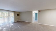 Located at 10 Drummond Dr in Rocky Hill, Connecticut, this two-bedroom, one-bathroom unit offers a practical and comfortable single-floor layout. The living room is generously sized, featuring neutral beige walls, wall-to-wall carpeting, and a sliding glass door with vertical blinds that fills the space with natural light. A wall-mounted air conditioning unit and baseboard heating provide year-round climate control.

The kitchen is equipped with warm honey-toned wood cabinetry, laminate countertops, a stainless steel sink, and white appliances including a refrigerator, electric range, and dishwasher. Hardwood-style flooring adds a clean, durable finish to the kitchen area.

The primary bedroom is a well-proportioned retreat featuring plush carpeting, a window with outdoor views of surrounding greenery, and two closets offering generous storage. The second bedroom is equally comfortable, with carpeting, a window, and baseboard heating.

The full bathroom is finished with wood-style flooring, a vanity with a single sink and warm-toned countertop, and a full tub-shower combination with a clean white surround. Three closets throughout the unit provide ample storage. A connecting hallway ties all rooms together efficiently, creating a cohesive and functional floor plan well-suited for everyday living.