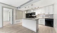 This 440 square foot apartment in Atlanta's Buckhead area offers a thoughtful layout that maximizes living space. The single-floor plan features one bedroom, one bathroom, and an open-concept living area. The bedroom, measuring 140 square feet, provides ample space and includes a window with horizontal blinds, allowing natural light and privacy control. The modern kitchen is a highlight, boasting white cabinetry, granite countertops, and stainless steel appliances. A breakfast bar with pendant lighting separates the kitchen from the living area, enhancing the open feel. The bathroom is efficiently designed with a shower/tub combination and a granite-topped vanity. Throughout the apartment, neutral wall colors and carpeting in the bedroom create a blank canvas for personalization. The living area features wood-look flooring, adding warmth to the space. Despite its compact size, the apartment's design ensures a comfortable and functional living environment.