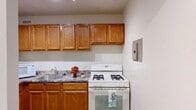 Located at 1225 L St NW in the vibrant heart of Washington, DC, this efficiently designed unit offers a practical and functional layout across a single floor. The living room is a bright, open space featuring light-toned hardwood-style flooring and two large floor-to-ceiling sliding glass doors dressed with vertical blinds, allowing generous natural light to fill the room. A wall-mounted climate control unit provides comfort throughout the seasons.

The kitchen is well-appointed with warm honey-toned wood cabinetry spanning both upper and lower sections, offering ample storage. Granite-style countertops provide a durable workspace, complemented by a stainless steel sink and a white gas range. The kitchen continues the same light flooring found throughout the unit, maintaining a cohesive aesthetic.

Two bathrooms serve the space, each featuring clean white tile surrounds with a tub-shower combination, maintaining a crisp and functional design. Two closets provide practical storage solutions within the unit.

The neutral warm-beige wall palette throughout creates a calm, versatile backdrop suitable for a variety of furnishing styles. Track lighting adds a modern touch in select areas. This well-located unit places residents steps away from premier dining, shopping, and transit options in one of DC's most sought-after neighborhoods.