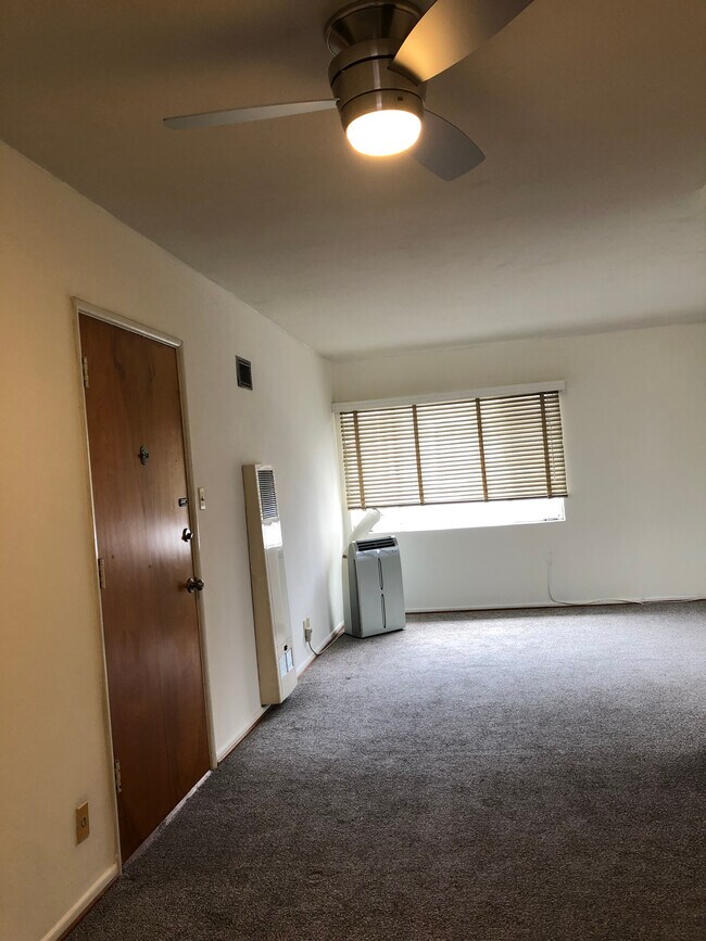 To the right of the front door is a dining area with a modern ceiling fan. - 7624 Norton Ave