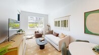 Located at 2525 First Avenue in San Diego's vibrant 92103 neighborhood, this thoughtfully designed one-bedroom, one-bathroom residence offers a well-appointed layout across a single floor. Light-toned hardwood flooring and crisp white walls create a bright, cohesive aesthetic throughout.

The kitchen is a standout feature, showcasing slate-blue lower cabinetry paired with natural wood upper cabinets, gold hardware accents, white quartz countertops, a textured tile backsplash, and a full suite of stainless steel appliances including a gas range and French door refrigerator. It opens seamlessly into a combined dining area, ideal for everyday living and entertaining.

The living area is airy and sun-drenched, with large windows offering lush outdoor views and ample natural light. The bedroom is a serene retreat, featuring a window with greenery views, and is complemented by two closets, including a spacious walk-in.

The bathroom is clean and modern, with a glass-enclosed walk-in shower featuring white tile, mosaic tile flooring, and matte black fixtures. Additional highlights include an in-unit laundry area and a private patio, enhancing both convenience and outdoor living. Recessed lighting throughout ties the space together with a polished, contemporary finish.