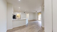 Located at 2515 Fenton Pkwy in San Diego, CA, this single-story home offers four bedrooms and two bathrooms within a well-designed, functional floor plan. The open-concept kitchen and living area serves as the heart of the home, showcasing a striking marble-look quartz peninsula island, crisp white shaker cabinetry, stainless steel appliances including a gas range, microwave, and refrigerator, and recessed lighting throughout. Wood-look flooring runs consistently across the living spaces and hallways, lending warmth and cohesion to the interior. The spacious primary bedroom features a ceiling fan and a sliding glass door that opens to an outdoor balcony, bringing in natural light and fresh air. The additional bedrooms are generously sized with neutral walls and the same wood-look flooring, offering versatile living arrangements. Both bathrooms are finished in a clean, bright palette, each equipped with a full tub-shower combination, chrome fixtures, and white vanities. A dedicated laundry room houses a front-loading washer with built-in shelving above. Two hallways provide efficient circulation throughout the home, complemented by a closet for additional storage. The overall aesthetic is modern and move-in ready.