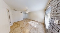 Located at 3325 East Pinchot Avenue in Phoenix, AZ, this single-floor, one-bedroom, one-bathroom unit offers an efficient and well-organized layout. The living area is bright and open, featuring large neutral-toned tile flooring that extends throughout the entire unit, white walls, and a ceiling fan with a light fixture that enhances air circulation. Windows fitted with blinds allow natural light to filter in, creating a warm and inviting atmosphere.

The kitchen is thoughtfully designed in a U-shaped configuration, featuring rich warm-toned wood cabinetry, recessed lighting, stone-look countertops, and white appliances including a refrigerator, electric range, and a sink with a window above it — providing both functionality and character.

The bedroom is a standout space, distinguished by exposed brick accent walls that add texture and a distinctive architectural touch. A ceiling fan, tiled flooring, and a window with blinds complete the room. An adjacent closet provides practical storage.

The bathroom is clean and straightforward, offering a combined tub and shower unit with chrome fixtures and a standard toilet, all finished in crisp white tones. The unit's compact footprint makes it easy to maintain while offering all the essential amenities for comfortable single-occupancy living in the heart of Phoenix.