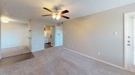 This single-story, two-bedroom, one-bathroom unit features a practical and comfortable layout designed to maximize everyday living. The living room serves as the central gathering space, finished with plush neutral carpeting, a textured ceiling, and a ceiling fan with integrated lighting. A corner fireplace adds a notable focal point, creating a warm and inviting atmosphere. The living area flows openly toward the kitchen, which is equipped with medium-toned wood cabinetry, granite-look countertops, a four-burner electric range, refrigerator, and a built-in range hood. Hard-surface wood-style flooring runs through the kitchen and entry areas, providing easy maintenance.

The two bedrooms are carpeted and offer generous proportions, with neutral wall tones and natural light from windows fitted with blinds. One bedroom provides direct sightlines to the kitchen, while another includes an adjacent vanity area. The bathroom features a framed mirror, a wood-toned vanity with a single sink, and a wall-mounted storage cabinet. A dedicated laundry nook with washer/dryer connections and a storage shelf adds convenience. Overall, the unit presents a clean, functional aesthetic suited for comfortable daily living.