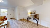 This thoughtfully designed single-story home in Roy, Utah offers a warm, neutral aesthetic with clean lines and an efficient layout across three bedrooms and two bathrooms. Light wood-tone flooring flows through the welcoming entryway, living room, kitchen, dining area, and bathrooms, creating a cohesive and bright feel throughout.

The inviting living room is generously sized, offering ample space for relaxing and entertaining. The kitchen stands out with its two-tone cabinetry — crisp white uppers paired with natural wood lowers — complemented by white countertops, open shelving, a central island, and a full suite of stainless steel appliances. Adjacent to the kitchen, the dining area comfortably accommodates a full dining set and features warm accent décor.

The spacious primary bedroom is carpeted and features windows that allow natural light to fill the room. Additional bedrooms are versatile, with one easily serving as a home office. Each room benefits from dedicated closet space, with three closets distributed throughout the home.

Both bathrooms are finished with light wood vanities, white countertops, and wood-tone flooring. One features a tub-shower combination, while the other is designed as a half or three-quarter bath. A utility room rounds out the functional layout of this well-maintained home.