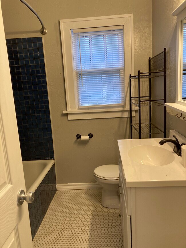 Baño con suelos de baldosas originales y bañera grande y profunda. - 1503 N Broadway Ave