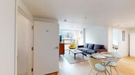 Located in the heart of Philadelphia, this modern 2-bedroom, 1-bathroom unit offers a clean, contemporary design throughout. Light wood flooring flows seamlessly across the entire space, complemented by crisp white walls that enhance the bright, airy atmosphere.

The open-plan living and dining area makes efficient use of space, with large floor-to-ceiling windows framing sweeping city skyline views and flooding the room with natural light. The kitchen is well-appointed with white cabinetry, stainless steel appliances including a refrigerator, dishwasher, microwave, and range, along with ample counter and storage space.

The primary bedroom features a generous window with urban views, providing excellent natural light, while the second bedroom also benefits from a large window overlooking the Philadelphia cityscape. Both bedrooms feature warm wood flooring and clean-lined finishes.

The bathroom is neatly designed with a gray vanity, mirror, and a shower-tub combination, maintaining the unit's modern, minimalist aesthetic. Throughout the space, the consistent use of neutral tones, natural light, and modern fixtures creates a cohesive and functional living environment well-suited to urban living in Center City Philadelphia.