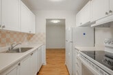 Located at 82 Millside Dr in Milton, Ontario, this one-bedroom, one-bathroom unit offers a well-organized layout across a single floor. Warm hardwood-style flooring flows throughout the living spaces, lending a cohesive and inviting feel to the interior.

The galley-style kitchen is efficiently designed with white cabinetry, a ceramic tile backsplash, a double sink, and white appliances including a refrigerator, stove, and dishwasher. It opens toward the dining area, creating a practical flow for everyday living.

The living room is bright and generously proportioned, featuring a sliding glass door that leads to a private balcony with outdoor views — an ideal spot for natural light and fresh air. Adjacent to the living room, the dining area provides a comfortable space for meals.

The bedroom is a well-sized, quiet retreat featuring warm flooring, a window with exterior views, baseboard heating, and a dedicated closet with built-in shelving. Additional closet and hallway storage add to the unit's practicality.

The bathroom is finished with full-height beige ceramic wall tiles surrounding a soaker tub and shower combo, complemented by hardwood-style flooring. The textured ceilings present throughout the unit add a classic character to the overall design.