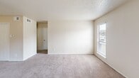 Located at 9455 Skillman St in Dallas, TX, this single-floor residence offers two bedrooms, two bathrooms, and a thoughtfully arranged layout. The combined kitchen and living area serves as the heart of the home, with the kitchen featuring white cabinetry, light stone-look countertops, tile flooring, and a pass-through counter that opens directly to the living space — creating a connected, open feel. White appliances, including a range and refrigerator, are included. The living area is carpeted and benefits from natural light through blinds-fitted windows. Both bedrooms are carpeted with neutral beige walls and textured ceilings, each offering a calm and functional space. The primary bedroom is generously sized and includes a dedicated closet. The second bedroom also features a closet and window with exterior views. Both bathrooms include a tub-shower combination with full ceramic tile surrounds in warm earth tones, providing a clean and durable finish. The overall aesthetic is consistent and understated, with light neutral tones throughout, making the space easy to personalize.