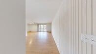 Located at 600 Kelly Ave in Wilkinsburg, PA, this single-floor unit offers three bedrooms and one bathroom with a clean, functional layout. The open living room is a standout feature, showcasing light hardwood flooring, bright white walls, and a full-width sliding glass door that opens to a private balcony with outdoor views — allowing abundant natural light to fill the space. A distinctive vertical-paneled accent wall adds a subtle architectural detail near the entrance.

The kitchen features white cabinetry, a neutral laminate countertop, tile flooring, and full appliances including a refrigerator, range, and dishwasher. Its efficient U-shaped layout makes practical use of the available space.

The three bedrooms each feature the same warm light wood flooring found throughout the unit, crisp white walls, and windows that bring in natural daylight. The primary bedroom includes a closet with sliding wood doors and hallway access. The additional bedrooms are well-proportioned and versatile.

The bathroom is finished with white tile in the tub surround, tile flooring, a vanity with storage, and a medicine cabinet with mirror. A hallway and entrance area connect the rooms and complete the straightforward, easy-to-navigate floor plan.