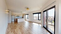 Located in Dayton's Webster Street corridor, this thoughtfully designed two-bedroom, two-bathroom unit offers a contemporary aesthetic throughout its well-proportioned single-floor layout. Light wood-tone flooring flows consistently across all living areas, complementing the clean white walls and modern gold and brass hardware accents found throughout the space.

The open-concept kitchen and living area serves as the heart of the unit, anchored by a generous quartz-topped island with an integrated sink and a rose-gold faucet. Two-tone cabinetry pairs light wood lower cabinets with white uppers, while a mosaic tile backsplash and stainless steel appliances complete the polished look. A gold pendant light fixture adds a refined finishing touch.

Both bedrooms feature large black-framed windows that frame elevated views of the Dayton skyline and surrounding neighborhood. The primary bedroom includes a ceiling fan with lighting, while the secondary bedroom features a gold wall sconce. Each room receives generous natural light throughout the day.

The two bathrooms are distinctly finished. One features white subway tile surrounding a soaking tub with a frameless sliding glass enclosure and brushed gold fixtures. The other offers a walk-in tiled shower, a wood-toned vanity with gold hardware, and large-format marble-look porcelain tile flooring, creating a spa-like atmosphere.