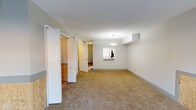 Located at 2603 Gloucester Rd in Augusta, Georgia, this two-floor property offers a functional layout across multiple levels. The main living area is generously proportioned, featuring neutral-toned carpet, textured ceilings, and wood panel wainscoting along the lower walls — a distinctive design detail that carries through several rooms. A pendant light fixture and a window with natural light anchor the open living space, while sliding glass doors provide direct access to an outdoor fenced area, allowing natural light to flow inward.

Additional carpeted rooms, painted in soft blue-gray tones, include ceiling fans and windows fitted with blinds, providing comfortable and well-lit spaces. The kitchen features light tile flooring, upper cabinetry, a window overlooking the outdoors, and includes a refrigerator. A bathroom on the property is outfitted with tile flooring, a tub-shower combination, and a vanity with warm wood cabinetry and a white countertop. Throughout the home, white six-panel doors, neutral wall tones, and consistent carpeting create a cohesive aesthetic. The upper level includes additional rooms with access via an interior hallway, completing the multi-level layout of this Augusta property.