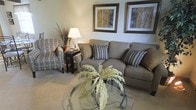 Located at 4365 Bayshire Rd in Groveport, Ohio, this two-story home presents a thoughtfully designed interior with a welcoming ambiance across both levels. The living area sets a comfortable tone, featuring plush carpeting underfoot and a neutral color palette that creates a calm, inviting atmosphere. A generously sized sofa paired with a coordinating accent chair provides ample seating, while a glass-topped coffee table adds a refined touch to the space. Tasteful framed artwork adorns the walls, complementing the warm, earthy tones found throughout. Soft, layered lighting from table lamps contributes to the cozy feel of the room. The layout across two floors allows for a natural separation of living and private spaces, offering both functionality and comfort. The overall design aesthetic leans toward a classic, understated style — clean lines, coordinated furnishings, and neutral tones work together to create a space that feels both livable and polished. This Groveport property combines practical layout with comfortable, carefully considered interior details, making it a well-rounded home suitable for a variety of lifestyles.