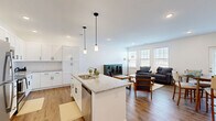 Located at 18183 Wheeler Rd in Westfield, Indiana, this well-appointed single-floor home offers a thoughtfully designed open-concept layout across two bedrooms and three bathrooms. The heart of the home is a bright, modern kitchen featuring white shaker cabinetry, granite countertops, stainless steel appliances, a double-basin island sink, and pendant lighting — all flowing seamlessly into the dining and living areas. The dining space accommodates a full table and benefits from a windowed door that brings in additional natural light. The living room is generously sized, with large windows that flood the area with daylight and wood-style flooring that extends throughout the main living spaces. The spacious primary bedroom includes plush carpeting, ample closet space with built-in wire shelving, and easy access to a well-finished en-suite bathroom with granite vanity and wood-look flooring. The second bedroom also features carpet flooring and a bright window. Three clean, modern bathrooms round out the home. With recessed lighting, neutral tones, and quality finishes throughout, this home offers a comfortable and contemporary living experience in Westfield, IN.