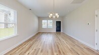 This contemporary 1,350 square foot home in Navassa, NC offers a thoughtful layout across two floors. The ground floor spans 570 sq ft, while the upper level provides 790 sq ft of living space. The home features three bedrooms, including a generous 180 sq ft primary suite, and three full bathrooms.

The interior is characterized by an open-concept design, showcasing light-filled rooms with hardwood flooring throughout. Large windows with white blinds allow ample natural light, complementing the neutral wall tones. The kitchen boasts white cabinetry, stainless steel appliances, and a functional island, ideal for meal preparation and casual dining.

Each bedroom offers spacious comfort, with the primary bedroom featuring an en-suite bathroom. The bathrooms are appointed with modern fixtures, including a sleek vanity and a tub-shower combination. Ample closet space, including wire shelving, provides storage solutions throughout the home.

Additional amenities include a single-car garage with a modern garage door system and recessed lighting. The property is enhanced by a fenced backyard, offering privacy and outdoor living potential. Located at 304 Bedstone Dr, this home combines modern aesthetics with practical living spaces, making it an attractive option for various lifestyle needs.