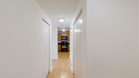 Located on the 14th floor at 115 Christina Landing Dr in Wilmington, Delaware, this one-bedroom, one-bathroom unit offers a thoughtfully laid-out single-floor plan. Light hardwood flooring flows consistently throughout the living room, bedroom, and hallway, lending the space a warm and cohesive feel.

The open living area is bright and airy, featuring clean white walls, a textured ceiling, and a sliding glass door that leads to a private balcony with outdoor views. A pendant light fixture adds a subtle design touch to the space.

The kitchen is functionally equipped with warm honey-toned wood cabinetry, dark granite-style countertops, and black appliances including an electric range and an over-the-range microwave, providing ample storage and prep space.

The bedroom is a well-proportioned retreat with a large window that draws in natural light and offers exterior views. It features access to a dedicated closet with built-in shelving, providing convenient storage solutions.

The bathroom maintains a consistent design palette with tile flooring, a wood vanity with dark countertop, a framed mirror, and clean white walls. A hallway and additional closet complete the layout, enhancing the overall functionality of this well-organized unit.