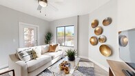 Located in Marana, Arizona, this single-story, 2-bedroom, 2-bathroom residence offers a thoughtfully designed layout with modern finishes throughout. The open-concept living room is bright and welcoming, featuring large black-framed windows that invite abundant natural light and views of the desert surroundings, a ceiling fan, and wood-look plank flooring that extends throughout the home.

The kitchen is well-equipped with dark wood cabinetry, white quartz countertops, a tile backsplash, and stainless steel appliances including a dishwasher, range, and microwave. A curved breakfast bar with seating provides a casual dining option and connects seamlessly to the living area.

The primary bedroom features a tray ceiling, a ceiling fan, a large window with outdoor views, and a dedicated closet. The second bedroom is equally comfortable, also outfitted with a ceiling fan and natural light. Both bathrooms mirror the home's modern aesthetic with dark cabinetry, white countertops, and wood-look flooring. A dedicated in-unit laundry area with shelving adds everyday convenience. Two hallways and two closets round out the efficient, functional floor plan of this clean, contemporary Marana residence.