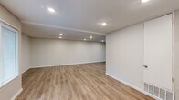 Located at 1000 Crystal Lake Cir in Macon, GA, this single-story home offers five bedrooms and two bathrooms with a clean, modern aesthetic throughout. Light wood-look luxury vinyl flooring runs consistently across the living spaces, complemented by crisp white walls, textured ceilings, and recessed lighting that keeps the interior bright and welcoming.

The open living room is generously sized, featuring large windows that invite natural light and provide views of the outdoors. The kitchen is well-appointed with white shaker-style cabinetry, marble-look countertops, a teal glass tile backsplash, stainless steel appliances including a refrigerator and range, and recessed lighting overhead.

Each of the five bedrooms is finished with the same wood-look flooring and neutral tones, and several rooms include built-in closets with white bifold doors and windows with blinds for natural light and privacy. The primary bedroom offers a comfortable, functional layout with ample closet space.

Both bathrooms feature tub-shower combinations surrounded by large-format marble-look tile in soft grey tones with chrome fixtures, lending a clean and polished feel. A hallway connects the bedroom wing to the main living areas, and a dedicated closet provides additional storage. This home offers practical, move-in-ready living with updated finishes throughout.
