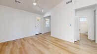 Located at 2701 S Woody Mountain Rd in Flagstaff, AZ, this two-bedroom, one-bathroom single-story home offers a thoughtfully designed layout with modern finishes throughout. The open-concept living area welcomes you through a white front door with sidelight, featuring light wood-look flooring, vaulted ceilings, and a ceiling fan that enhances the airy atmosphere.

The kitchen is a standout feature, showcasing gray shaker-style cabinetry, a decorative patterned tile backsplash, stainless steel appliances including a French door refrigerator, and a central island with a white quartz countertop, undermount sink, and stylish gold-toned pendant lighting. The combination of wood flooring and elevated ceilings makes this space feel bright and functional.

The two bedrooms offer a cozy retreat with plush carpeting, white walls, and windows with blinds that bring in natural light and views of surrounding greenery. The second bedroom features wood-look flooring and a window framing outdoor scenery.

The bathroom is finished with wood-look flooring, a white vanity with quartz countertop, a large mirror, and a window for natural light. A dedicated closet adds practical storage. The home's clean, contemporary palette and quality finishes make it a well-appointed residence in the Flagstaff area.