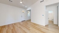 Located at 2701 S Woody Mountain Rd in Flagstaff, AZ, this two-bedroom, one-bathroom single-story home offers a thoughtfully designed layout with modern finishes throughout. The open-concept living area welcomes you through a white front door with sidelight, featuring light wood-look flooring, vaulted ceilings, and a ceiling fan that enhances the airy atmosphere.

The kitchen is a standout feature, showcasing gray shaker-style cabinetry, a decorative patterned tile backsplash, stainless steel appliances including a French door refrigerator, and a central island with a white quartz countertop, undermount sink, and stylish gold-toned pendant lighting. The combination of wood flooring and elevated ceilings makes this space feel bright and functional.

The two bedrooms offer a cozy retreat with plush carpeting, white walls, and windows with blinds that bring in natural light and views of surrounding greenery. The second bedroom features wood-look flooring and a window framing outdoor scenery.

The bathroom is finished with wood-look flooring, a white vanity with quartz countertop, a large mirror, and a window for natural light. A dedicated closet adds practical storage. The home's clean, contemporary palette and quality finishes make it a well-appointed residence in the Flagstaff area.