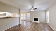 Located at 2525 Bolton Boone Dr in DeSoto, TX, this single-story, 2-bedroom, 3-bathroom home offers a well-organized layout with a comfortable mix of living spaces. The open-concept living and dining area serves as the heart of the home, featuring rich wood-look flooring, a ceiling fan with light fixture, and a white brick fireplace as a focal point. Multiple windows with blinds allow natural light to fill the space, while a patio door provides direct outdoor access to one of two patios. The galley-style kitchen is efficiently designed with white cabinetry, a double sink, light countertops, a skylight panel, and black appliances, including a refrigerator and range. The bedrooms are carpeted for comfort; the primary bedroom is generously sized and benefits from a ceiling fan, a window with natural light, and multiple closets, including a walk-in closet with built-in shelving and hanging rods. Four closets in total provide ample storage throughout the home. The three bathrooms include tiled tub-and-shower combinations. Additional functional spaces include a dedicated laundry room and a hallway connecting the main areas. Textured ceilings and neutral wall tones create a clean, cohesive aesthetic throughout.