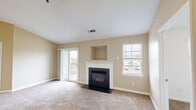 Located at 9 Forest Glen Cir in Middletown, CT, this single-floor, three-bedroom, one-bathroom home offers a well-organized layout across a comfortable footprint. The combined kitchen and living room serves as the heart of the home. The living room is bright and welcoming, featuring a classic fireplace with a white mantel and a built-in niche above, soft carpeting underfoot, and a sliding glass door that opens to a private balcony with neighborhood views. A secondary window further fills the space with natural light. The galley-style kitchen is equipped with white cabinetry, dark countertops, hardwood-style flooring, and black appliances including a refrigerator, electric range, and dishwasher. The three bedrooms are carpeted and finished with neutral tones, offering a calm and functional atmosphere. The primary bedroom is generously sized and provides direct access to the bathroom. One bedroom includes a walk-in closet outfitted with wire shelving for organized storage, as well as two six-panel doors leading to both the hallway and closet. The full bathroom features tile flooring, a combined tub and shower, and a vanity. The hallway connects all rooms efficiently, completing this practical and comfortable single-level home.