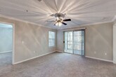 Located at 950 Lake Ridge Pkwy in Riverdale, GA, this well-appointed 2-bedroom, 2-bathroom residence offers a comfortable and functional single-floor layout. The open living and dining area is finished with warm hardwood-style flooring, crown molding, and an elegant chandelier, creating an inviting atmosphere throughout the common spaces. A kitchen peninsula with a dark granite countertop separates the kitchen from the living area, providing a natural gathering point.

The galley-style kitchen is thoughtfully equipped with white cabinetry, dark granite countertops, a full suite of appliances including a refrigerator, electric range, microwave, and dishwasher, along with a deep stainless steel sink.

The spacious primary bedroom features plush carpeting, a ceiling fan, crown molding, and a sliding glass door that opens to a private balcony with natural views. It is complemented by a generously sized walk-in closet with wire shelving on multiple walls for ample storage. The second bedroom also offers carpeted floors, a ceiling fan, and a bright window with outdoor views.

Both bathrooms include wood-look tile flooring, granite-topped vanities, and tub/shower combinations. A dedicated laundry room houses a full-size washer and dryer with an overhead storage shelf, adding everyday convenience to this well-rounded home.