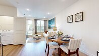 This thoughtfully designed single-floor residence offers a seamless open-concept layout that connects the living, dining, and kitchen areas into one cohesive and functional space. Light hardwood floors run throughout, lending warmth and continuity across every room.

The kitchen is a standout feature, showcasing white shaker cabinetry, granite countertops, stainless steel appliances, and a central island with bar seating illuminated by pendant lighting — ideal for both cooking and casual dining. Adjacent to the kitchen, the dedicated dining area comfortably accommodates a full-sized table and flows naturally into the living room, which is brightened by large windows and a glass door that invite generous natural light and outdoor views.

The bedroom is a tranquil retreat, featuring large windows with blinds and drapery, a ceiling fan, and a walk-in closet outfitted with built-in shelving and hanging rods for well-organized storage. The bathroom continues the home's clean aesthetic with white cabinetry, granite countertops, a framed mirror, and a tub-shower combination with subway tile surround. In-unit laundry is also accessible, adding everyday convenience. Throughout, the space maintains a bright, neutral palette that creates a calm and livable atmosphere.