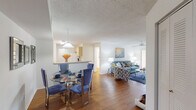 Located at 1900 Bella Vista Way in Port St. Lucie, Florida, this 2-bedroom, 3-bathroom single-floor residence offers a well-designed layout with a comfortable, functional flow throughout. The open-concept living and dining area is anchored by warm hardwood-style flooring and a textured ceiling with a ceiling fan, creating an inviting atmosphere. A sliding glass door in the living room opens to a private patio, framing peaceful outdoor views and filling the space with natural light. The kitchen features light wood cabinetry, a double-basin sink, a white appliance suite including a range and dishwasher, and a pass-through counter that connects seamlessly to the dining area. The primary bedroom is a generously proportioned retreat with soft carpeting, neutral tones, and ample room for furnishings. The second bedroom is similarly comfortable and well-lit. Three bathrooms serve the home, including one with a tub-shower combination and another with a walk-in shower, both finished in clean white tile. A hallway, closet, and staircase complete the layout, providing practical storage and circulation. Throughout the home, a neutral color palette and consistent finishes contribute to a bright, cohesive aesthetic well-suited to Florida living.