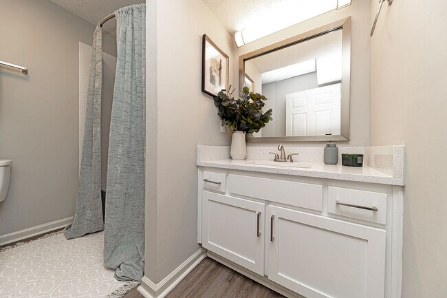 Baño luminoso con encimeras de cuarzo y armarios modernos. - Vetra Providence