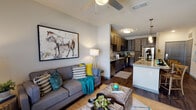 Located in Jacksonville, FL (32246), this single-floor residence offers a thoughtfully designed open-concept layout that seamlessly connects the kitchen, dining, and living areas. The kitchen is a standout feature, showcasing dark wood cabinetry with sleek hardware, granite countertops, a large center island with bar seating, and a full suite of stainless steel appliances including a refrigerator, range, microwave, and dishwasher. Wood-look flooring runs throughout the main living spaces, adding warmth and continuity.

The living room is bright and welcoming, with a ceiling fan, large windows that invite natural light, and direct sightlines to the kitchen — ideal for an open, connected lifestyle. The bedroom is carpeted for comfort and connects directly to a spacious walk-in closet with wire shelving and hanging rods for ample storage.

The bathroom is generously proportioned, featuring a double-sink vanity with dark cabinetry, wood-look flooring, a tub-shower combination, and recessed lighting. Throughout the residence, neutral wall tones and consistent finishes create a cohesive, modern aesthetic well-suited to everyday living in Jacksonville.