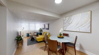 Located at 2100 Rue St-Marc in Montréal's vibrant H3H neighbourhood, this well-appointed one-bedroom, one-bathroom unit offers a thoughtfully organized layout across a single floor. Light hardwood flooring runs throughout, creating a warm and cohesive feel from room to room.

The open-plan living and dining area forms the heart of the unit. The living room is bright and welcoming, featuring large windows dressed with sheer curtains that allow generous natural light to fill the space. The dining area connects seamlessly to the kitchen and is large enough to comfortably accommodate a four-seat dining set.

The galley-style kitchen is efficiently designed with white cabinetry, subway tile backsplash, grey countertops, and stainless steel appliances including a full-size refrigerator, stove, built-in microwave, and dishwasher.

The bedroom is a comfortable, well-proportioned retreat with a large window, light hardwood floors, and a textured ceiling. It provides ample space for a full bedroom suite.

The bathroom is finished with neutral tile flooring, a tub-shower combination with white subway tile surround, and a white vanity with storage. Two hallways connect the rooms and provide functional transition spaces throughout the unit.