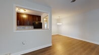 Located at 3 Ronald Dr in Colonia, NJ, this single-floor home offers a thoughtfully laid-out interior finished with warm hardwood-style flooring throughout. The open-concept living and dining area is bright and inviting, anchored by a classic chandelier pendant light and a ceiling fan that add both function and style. A pass-through window connects this space to the kitchen, creating an airy, connected feel ideal for everyday living and entertaining.

The kitchen is well-appointed with rich dark wood cabinetry, a tile backsplash, black appliances including a gas range and refrigerator, and a stainless steel sink positioned beneath a window that brings in natural light. A peninsula counter extends into the pass-through, providing convenient additional workspace or casual seating.

The bedrooms are comfortably sized, each featuring hardwood-style flooring, neutral wall tones, and windows with blinds that allow for natural light and privacy. Ceiling fans are present in several rooms, and baseboard heating runs along the walls throughout the home.

The bathroom is cleanly updated, showcasing large-format tile flooring, a dark-vanity with a white countertop, a tub-shower combination with a sliding glass door, and a mirrored medicine cabinet. The overall aesthetic of the home is clean, neutral, and move-in ready.