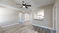 Located at 1750 W Boston St in Chandler, AZ, this 2-bedroom, 2-bathroom single-story home offers a well-designed layout with modern finishes throughout. Light gray wood-look flooring extends across the entire home, complemented by neutral-toned walls and crisp white trim, creating a clean and cohesive aesthetic.

The combined kitchen and living area serves as the heart of the home. The living room is anchored by a striking stone fireplace with a wood mantel and is equipped with a ceiling fan, textured ceiling, and vertical blinds allowing natural light to filter in. The kitchen features white shaker-style cabinetry, gray quartz-style countertops, a subway tile backsplash, stainless steel appliances including a refrigerator, dishwasher, microwave, and range, plus a black matte sink and fixtures. A pass-through breakfast bar connects the kitchen to the living area.

Both bedrooms include ceiling fans, closets, and windows with outdoor views. The primary bedroom offers a notably generous footprint. Six closets throughout the home provide ample storage. Both bathrooms mirror each other in design, each featuring a white vanity cabinet, gray countertop, black matte hardware, a mirror, and wood-look flooring. A dedicated laundry area with in-unit hookups adds everyday convenience.