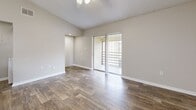 Located in Orlando, FL, this one-bedroom, one-bathroom residence offers a well-designed single-floor layout with a cohesive blend of modern finishes and functional living spaces. Rich wood-look flooring flows throughout the main living areas, complementing the neutral color palette that lends a clean, airy feel to the interior.

The open-concept living, dining, and kitchen area forms the heart of the home. The living room features vaulted ceilings with a ceiling fan and receives natural light through a window, creating a bright and comfortable atmosphere. Sliding glass doors lead to a private balcony, extending the living space outdoors. The kitchen is equipped with stainless steel appliances, white cabinetry, granite-style countertops, and an peninsula with an integrated sink and pendant lighting overhead — ideal for casual dining or meal prep.

The spacious bedroom is finished with plush carpet, a ceiling fan, and a window providing natural light. It offers direct access to a dedicated closet and the full bathroom, which features granite countertops, white cabinetry, a tub-shower combination, and matching wood-look flooring. Additional conveniences include a laundry area, utility room, and two closets for ample storage throughout.