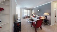 This single-story, 2-bedroom, 2-bathroom home offers a practical and comfortable layout with well-defined living spaces throughout. The living room serves as the heart of the home, featuring plush carpeting, crown molding, and a neutral color palette accented by a bold gray feature wall. A large window allows natural light to fill the space, creating a warm and inviting atmosphere.

Adjacent to the living room, the dining area benefits from a corner window configuration that provides abundant natural light and outdoor views, making it an ideal spot for everyday meals or entertaining. The galley-style kitchen is positioned nearby with an open pass-through counter connecting it to the living area. It features white cabinetry, ample counter space, and hardwood-style flooring.

Both bedrooms are carpeted and well-sized, each featuring windows with natural light, ceiling fans, and access to walk-in closets with built-in shelving. The primary bathroom includes a soaking tub, a single-sink vanity with cabinet storage, and tile flooring. The second full bathroom mirrors this design with a tub/shower combination, a vanity, and matching tile flooring, providing a cohesive aesthetic throughout the home.