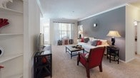 This single-story, 2-bedroom, 2-bathroom home offers a practical and comfortable layout with well-defined living spaces throughout. The living room serves as the heart of the home, featuring plush carpeting, crown molding, and a neutral color palette accented by a bold gray feature wall. A large window allows natural light to fill the space, creating a warm and inviting atmosphere.

Adjacent to the living room, the dining area benefits from a corner window configuration that provides abundant natural light and outdoor views, making it an ideal spot for everyday meals or entertaining. The galley-style kitchen is positioned nearby with an open pass-through counter connecting it to the living area. It features white cabinetry, ample counter space, and hardwood-style flooring.

Both bedrooms are carpeted and well-sized, each featuring windows with natural light, ceiling fans, and access to walk-in closets with built-in shelving. The primary bathroom includes a soaking tub, a single-sink vanity with cabinet storage, and tile flooring. The second full bathroom mirrors this design with a tub/shower combination, a vanity, and matching tile flooring, providing a cohesive aesthetic throughout the home.
